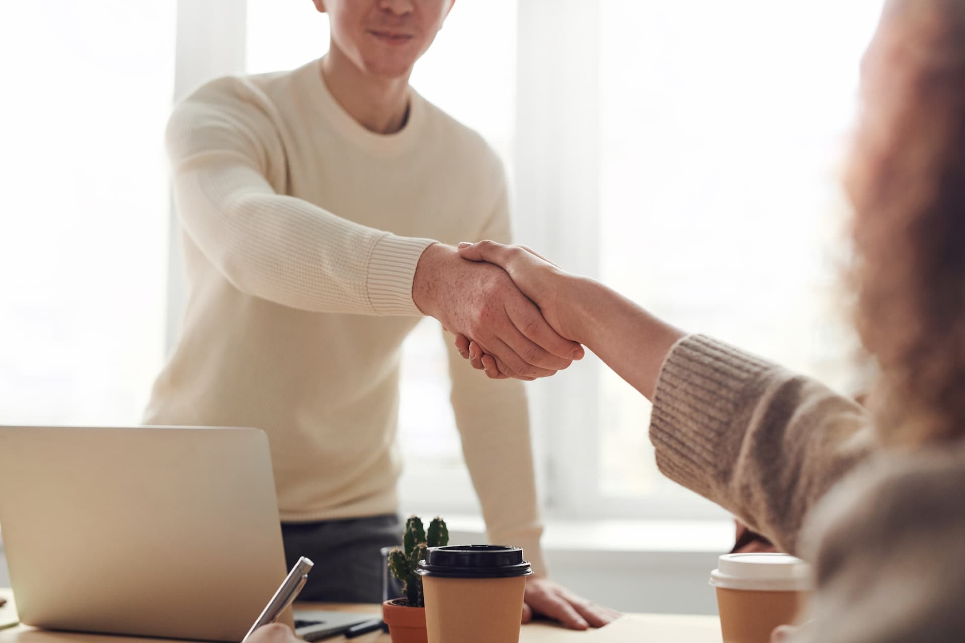 Man shaking woman's hand welcoming her to the office
