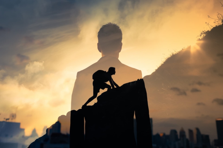 Man feeling determined climbing up a steep mountainside.