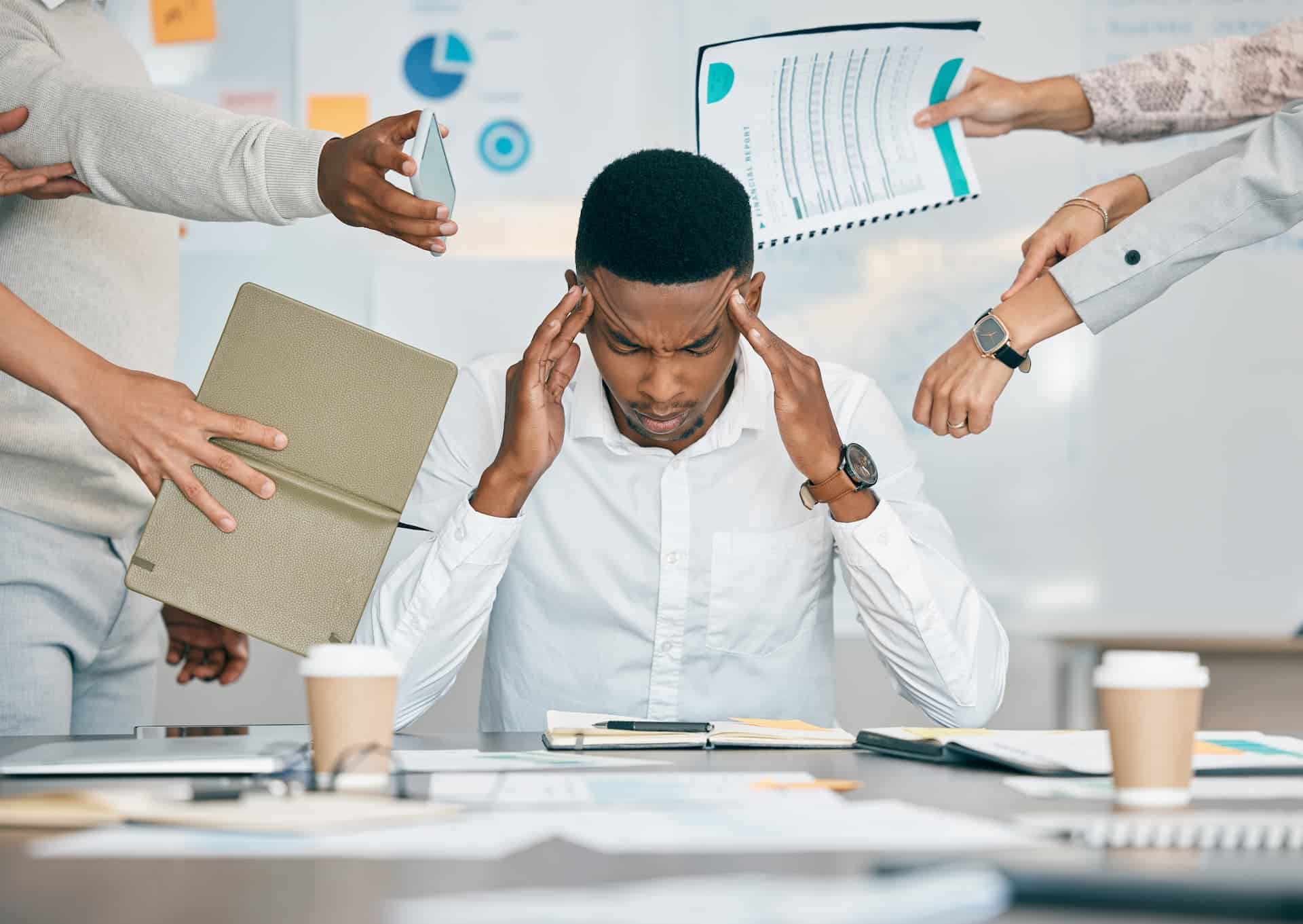 Man stressed out by all his tasks and coworkers' pressure.