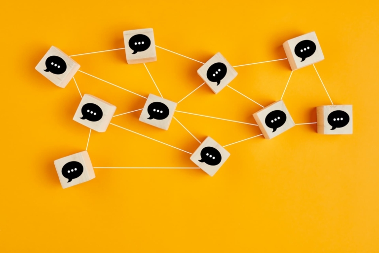 Dice with speech bubbles on a table interconnecting with drawn lines.