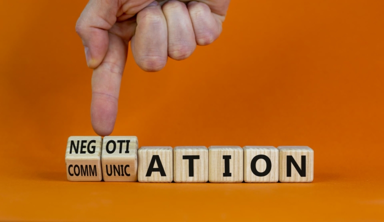 Dice-sized cubes spelling out negotiation, being moved so that it also spells communication.