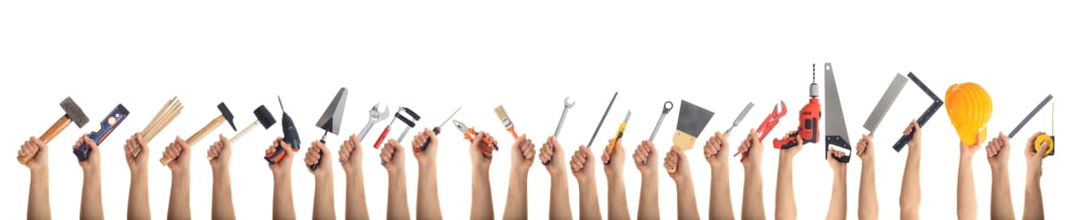 Hands holding construction tools isolated on white background.