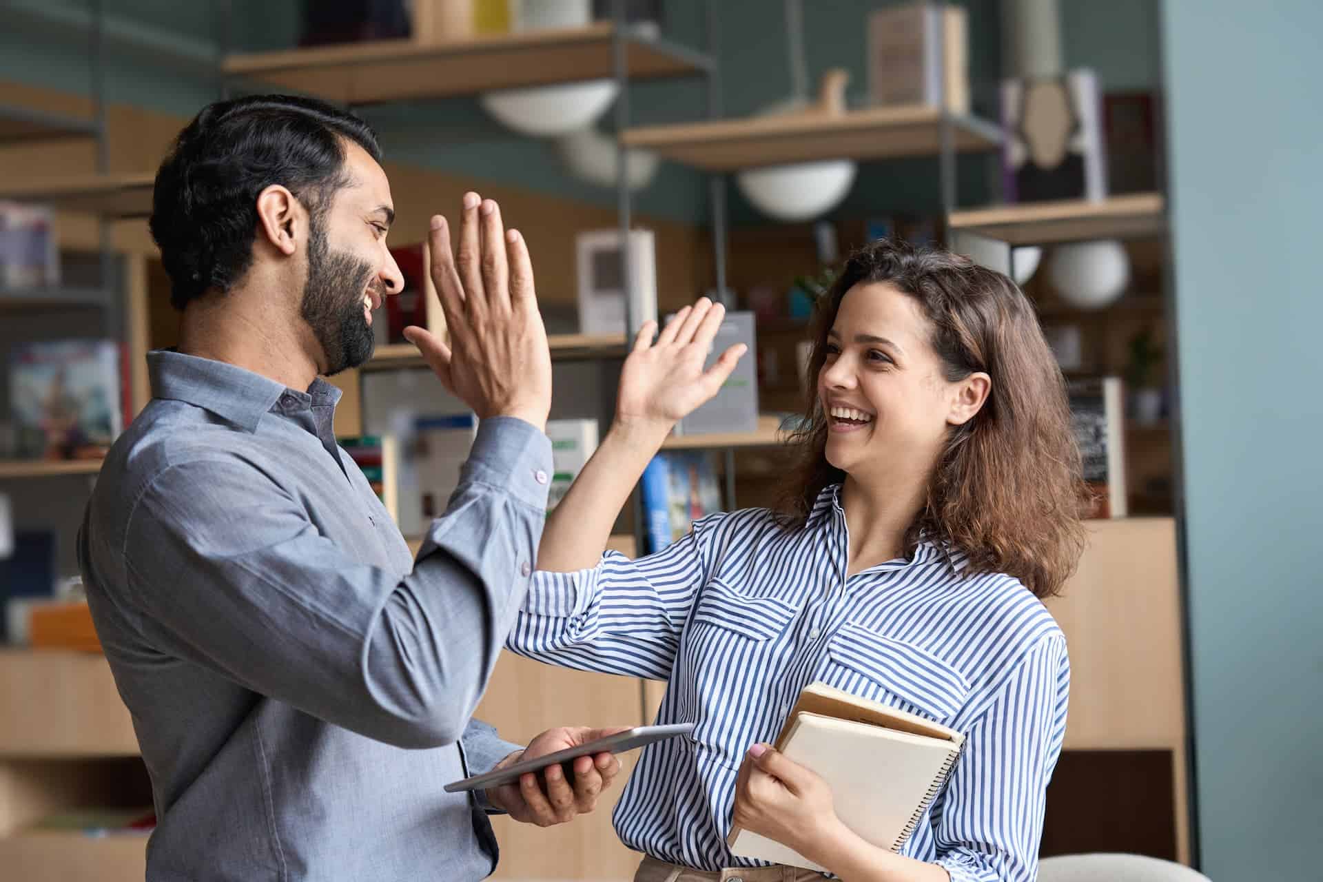 Man and woman high-fiving.