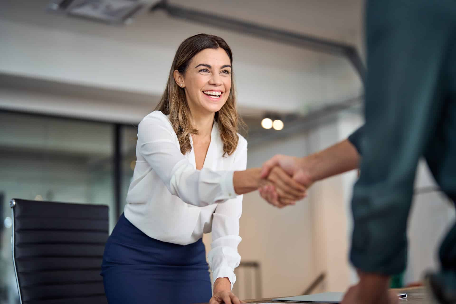 Woman interviewee shaking hands with interviewer.