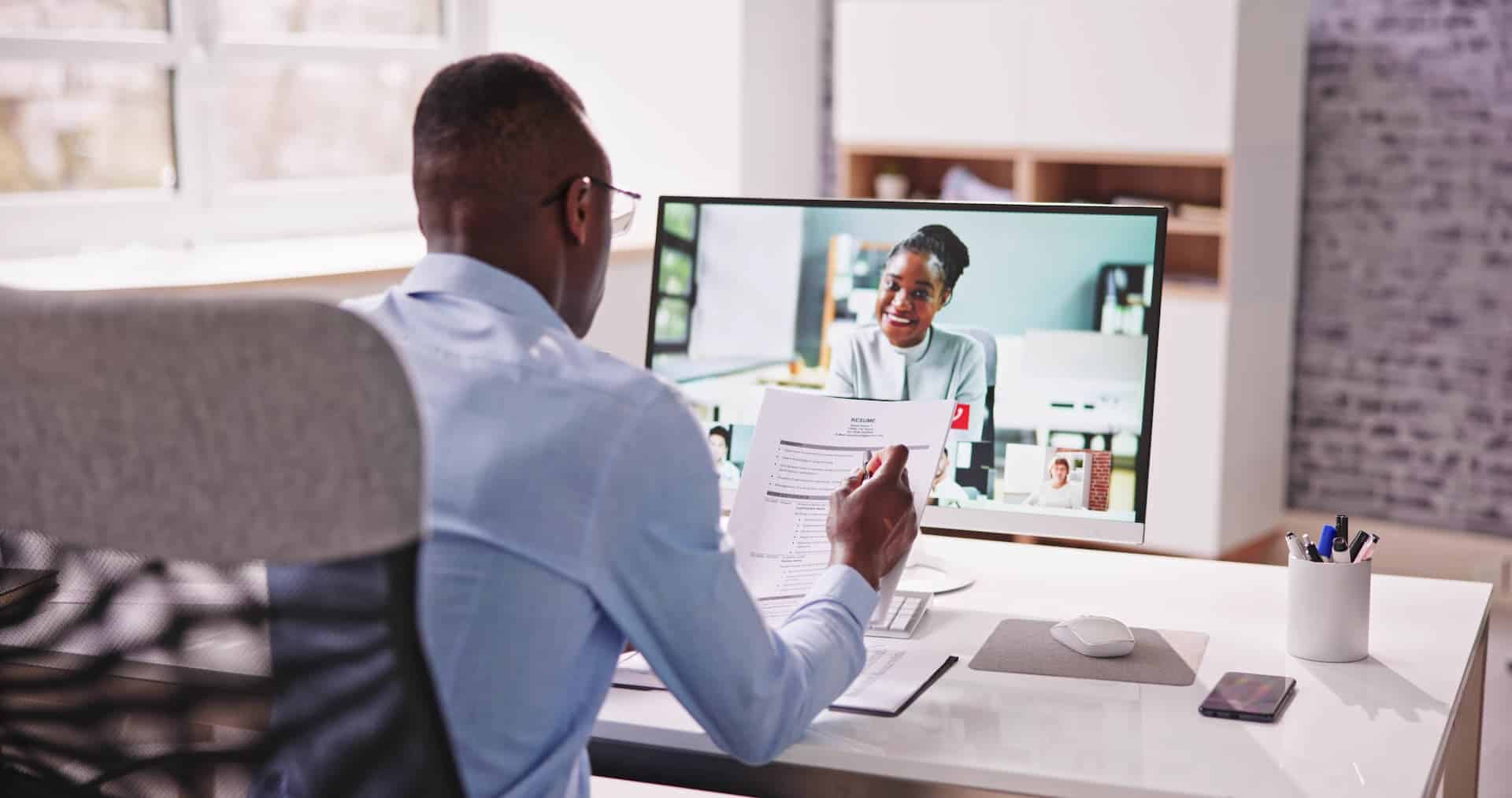 Man interviewing a woman through a video conference