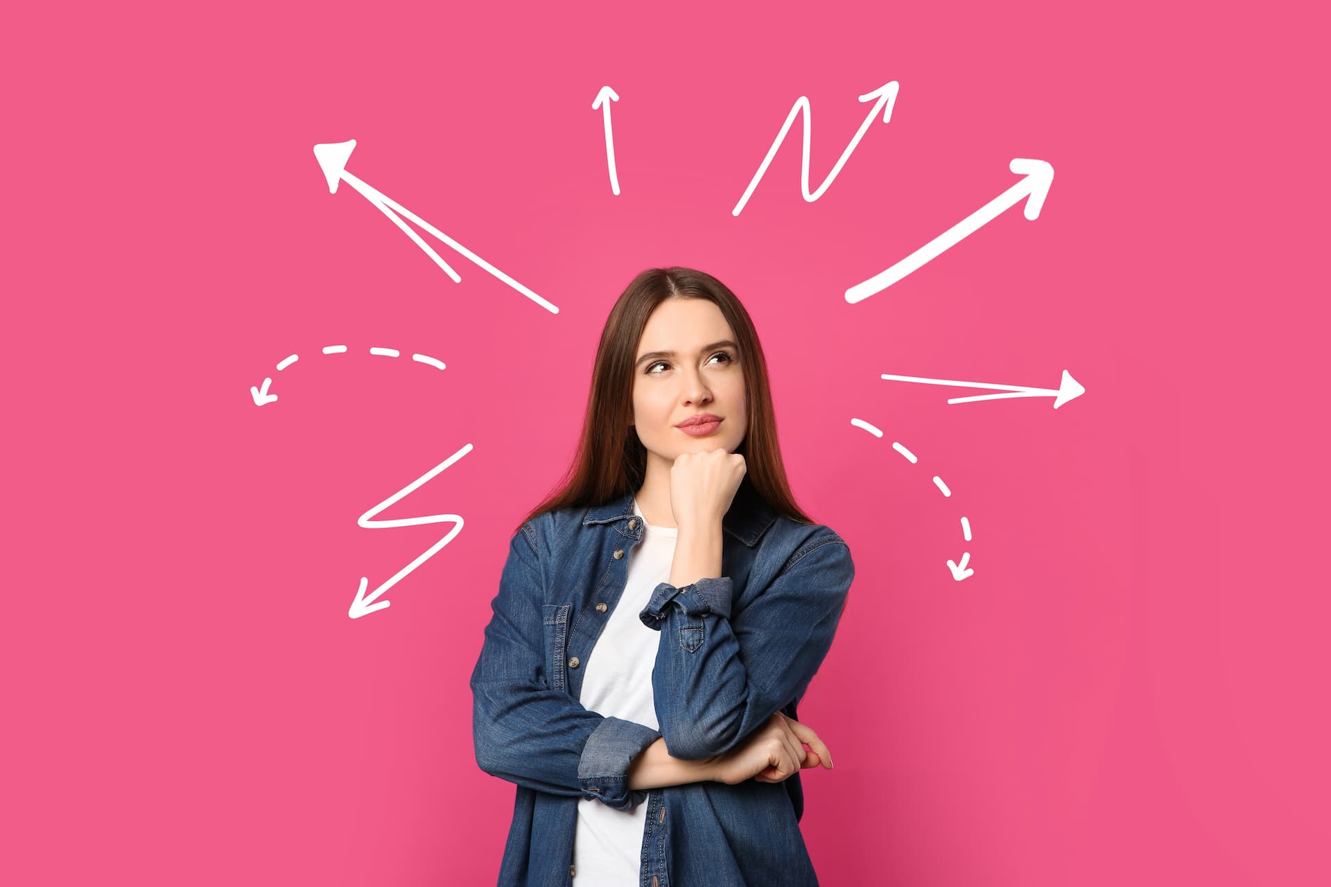 Young woman on pink background amidst arrows pointing in different directions, signaling a decision to make.