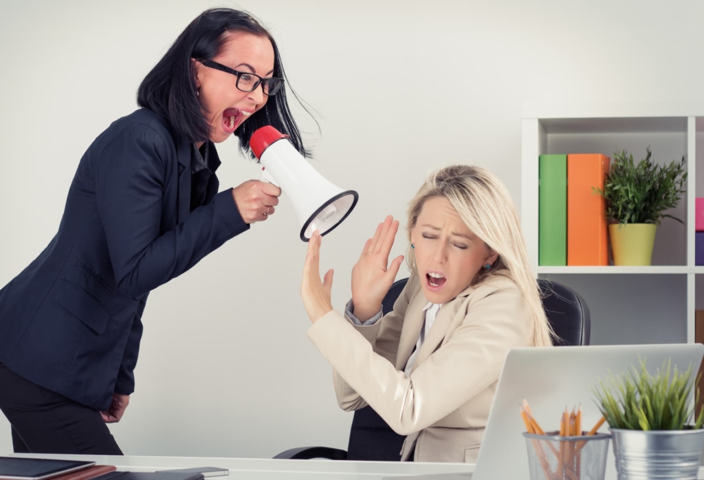 Difficult boss shouting at employee through a megaphone.