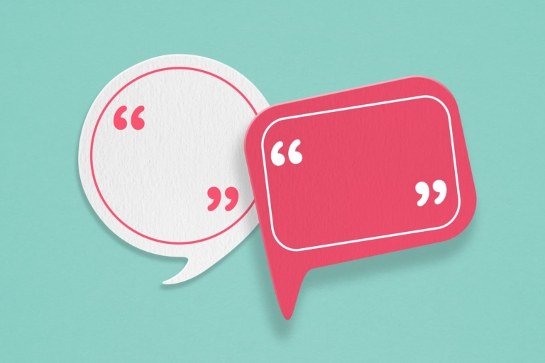 Blank pink and white paper speech bubbles on rough light green paper.