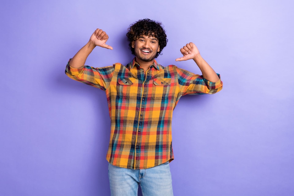 A successful young businessman confidently points towards himself, symbolizing personal branding and entrepreneurship success.