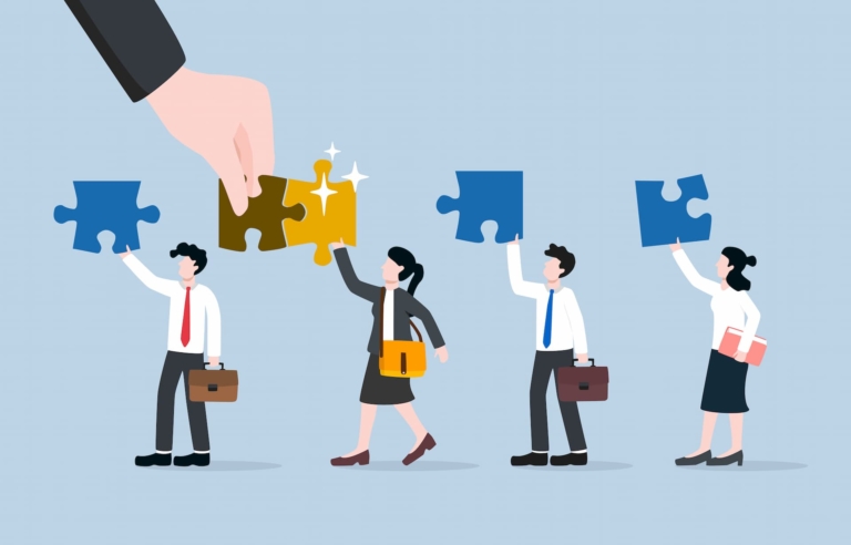 Three professionals hold a puzzle piece above their head while a large hand connects an interlocking piece into the fourth professional's puzzle, representing career alignment and growth.