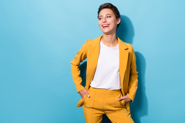 An elegant woman confidently adorned in a striking yellow suit, portraying executive presence.