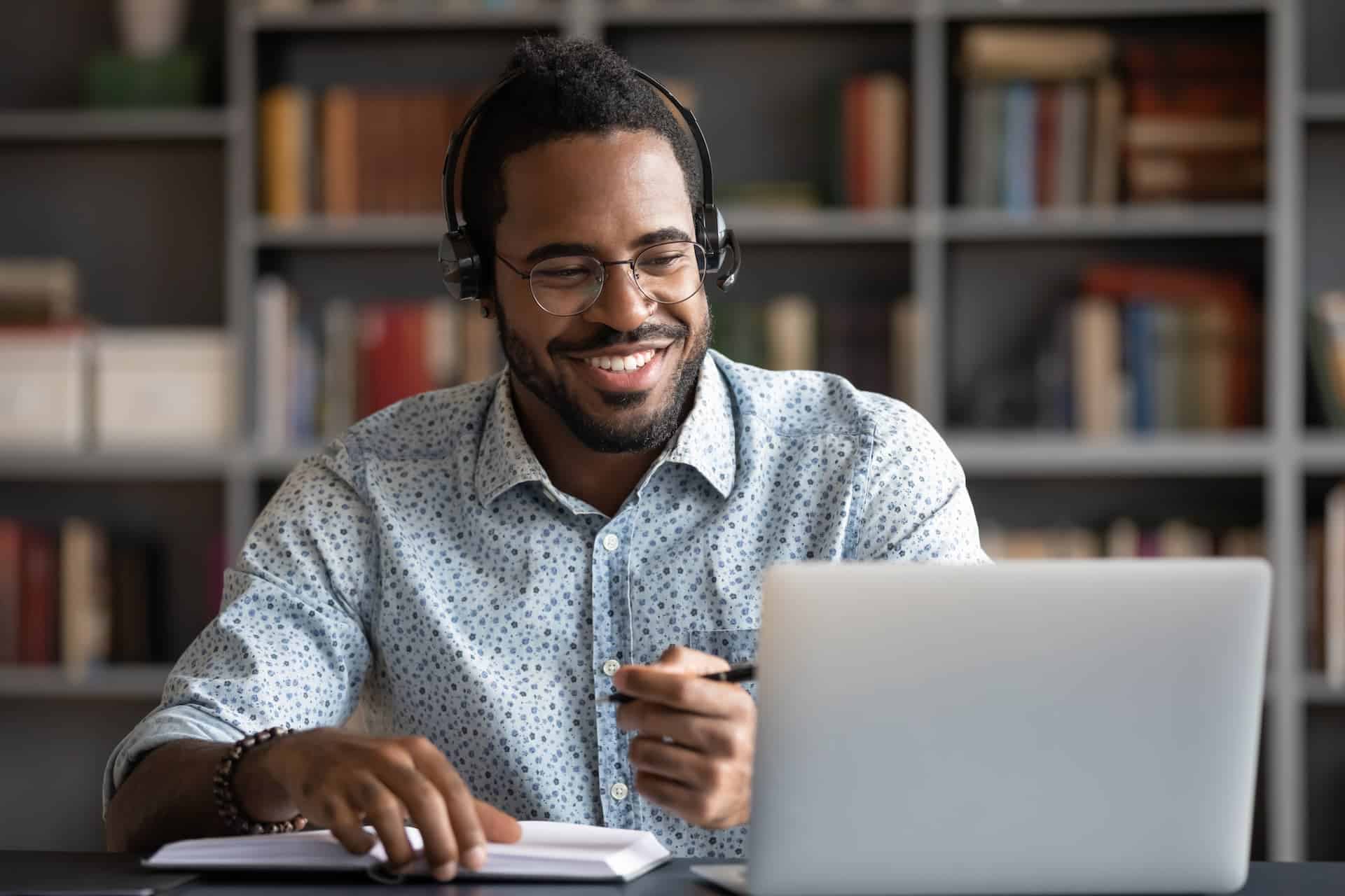 Smiling man working on his laptop with a look of motivation and engagement.