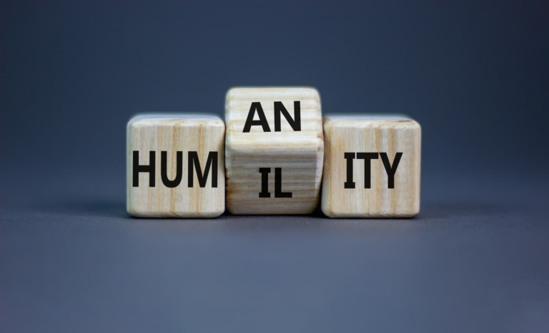 Three dice arranged to spell Humanity, with the middle die turning to show I L, changing the word to Humility.