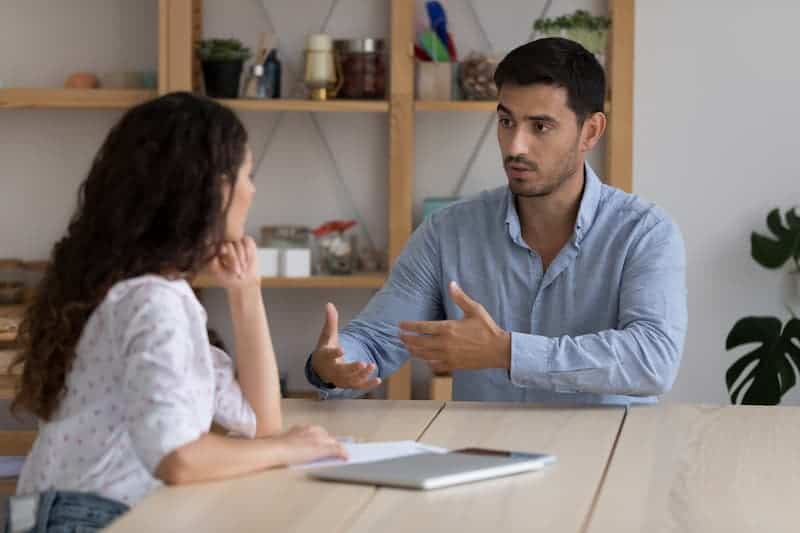 Two coworkers engaged in a candid conversation, discussing and resolving a conflict in a professional setting.