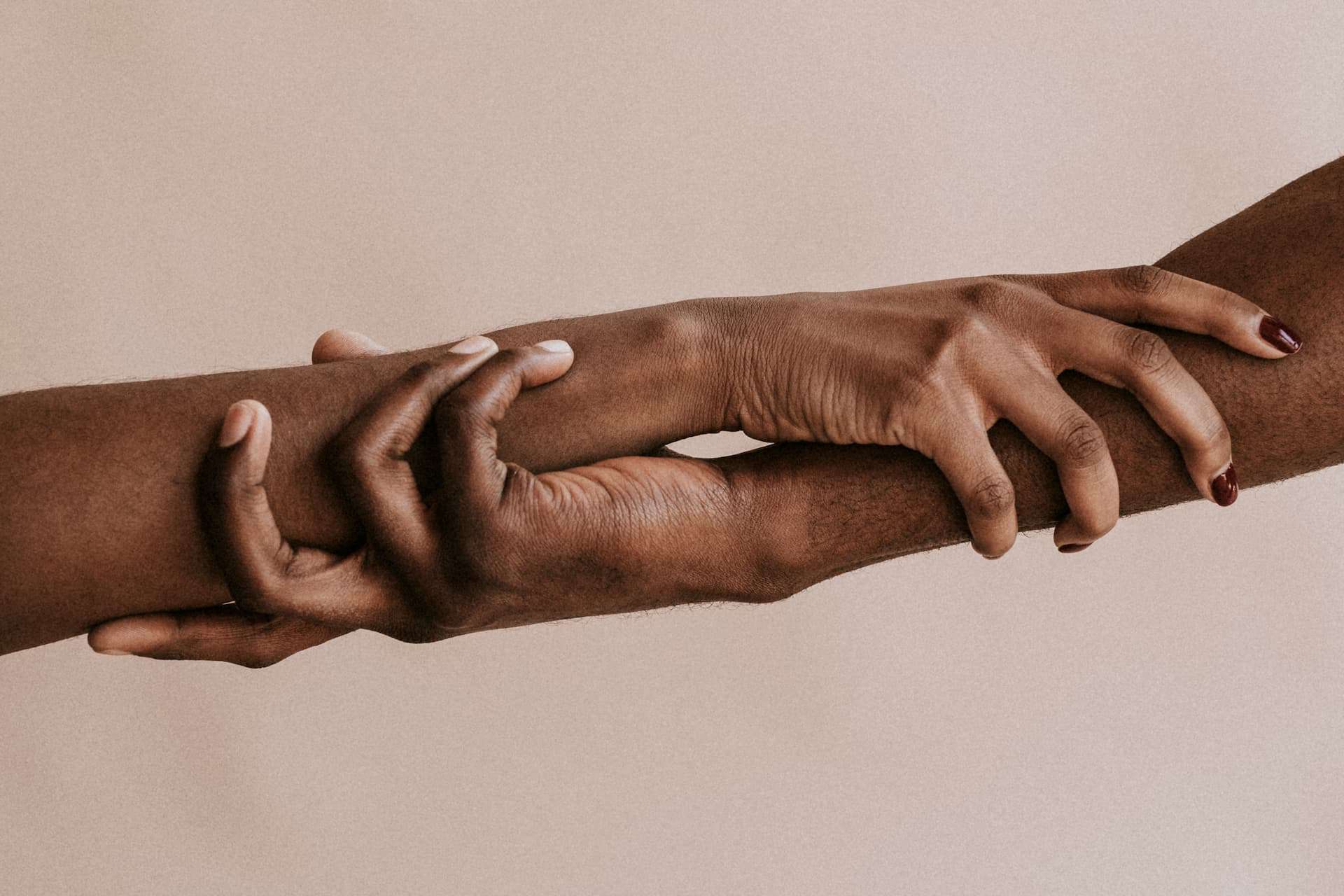 Two hands clasped, with one pulling the other upward, representing empowerment, mentorship, and the role of leadership in fostering a lasting legacy.