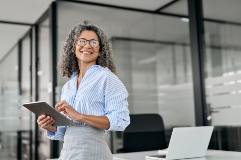 A woman manager smiling after successfully advocating for herself at work.