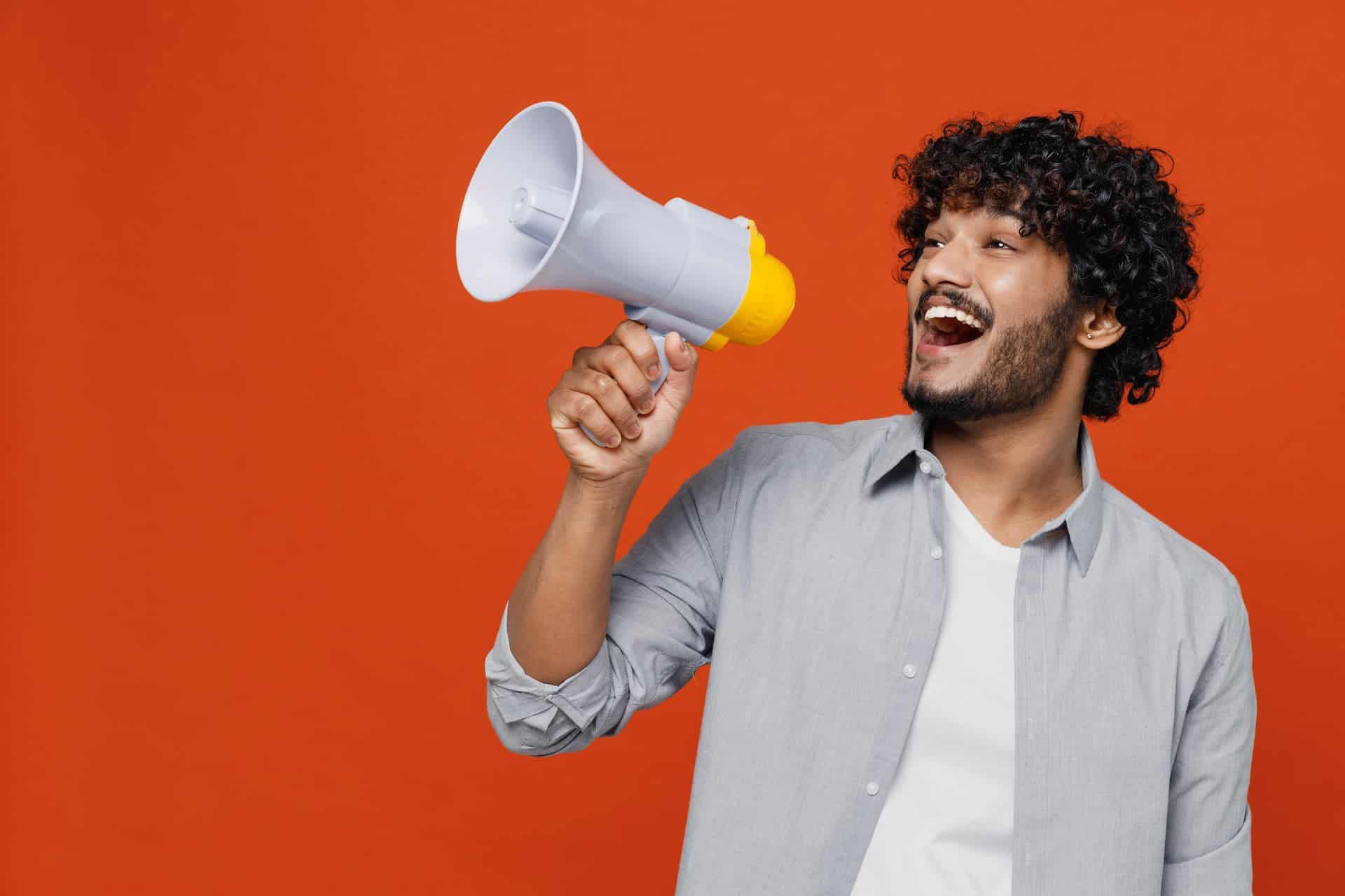 A man holding a megaphone, symbolizing self-advocacy by speaking up and asserting his voice.
