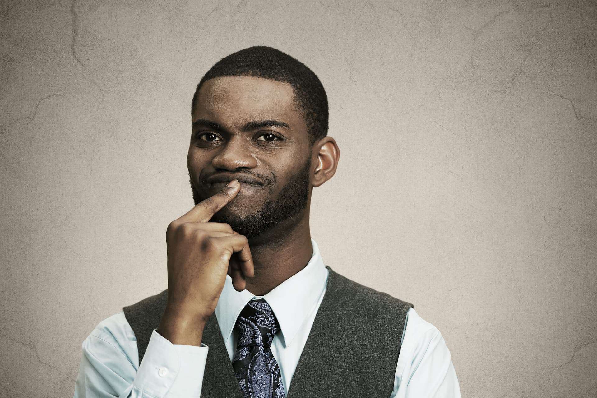 A man with a thoughtful, slightly confused expression, showing body language that suggests he is processing information.