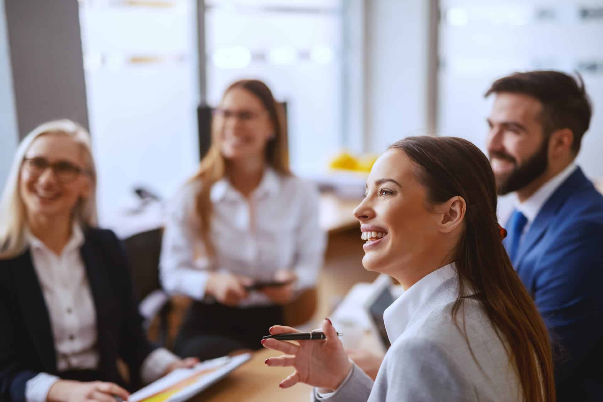 A happy team collaborating in a meeting, displaying enthusiasm and a shared sense of purpose in their work.