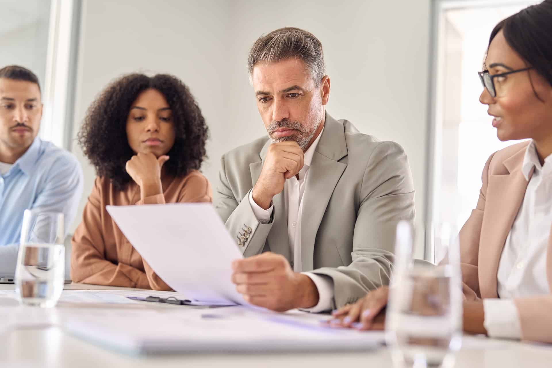 A group of colleagues gathered in an office to discuss and evaluate options to make a well-judged decision.