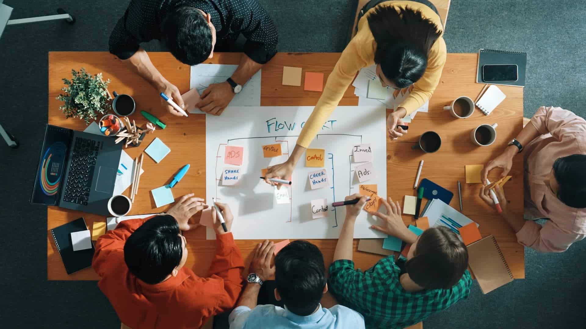 A group of team members working over a table, showing a collaborative effort to overcome a challenge, demonstrating the power of team persistent problem-solving.