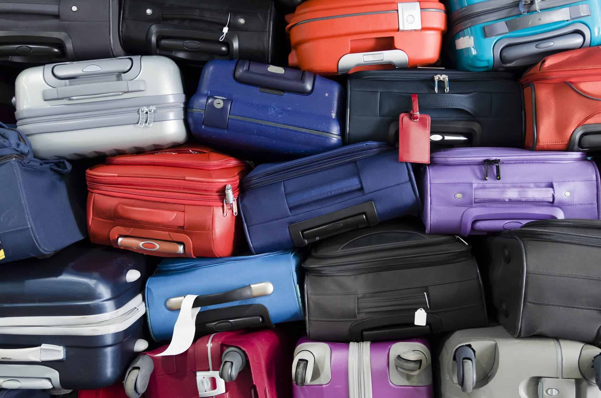 Stack of colorful suitcases arranged one on top of the other, ready for transport.