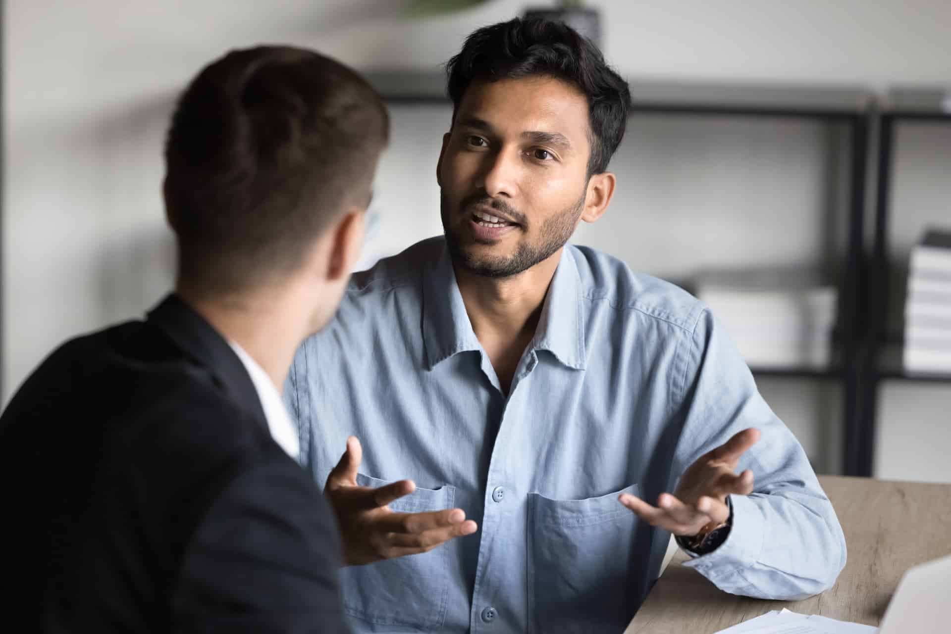 A manager and a subordinate having a conversation guided by smart questions.