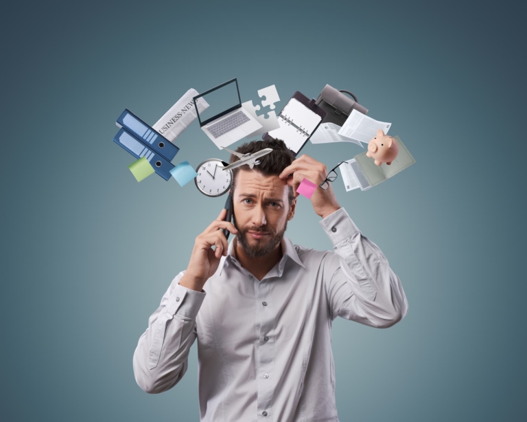 A man overwhelmed by tasks and deadlines, illustrating the need for effective stress management.