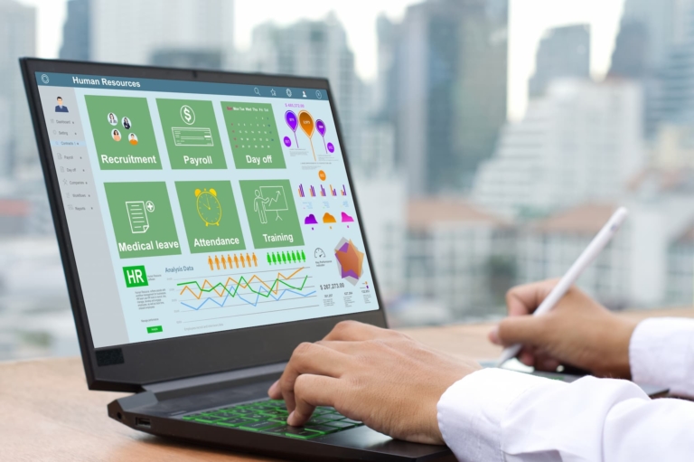 A man's hands on a laptop, synthesizing data insights while working with his iPad, analyzing charts.