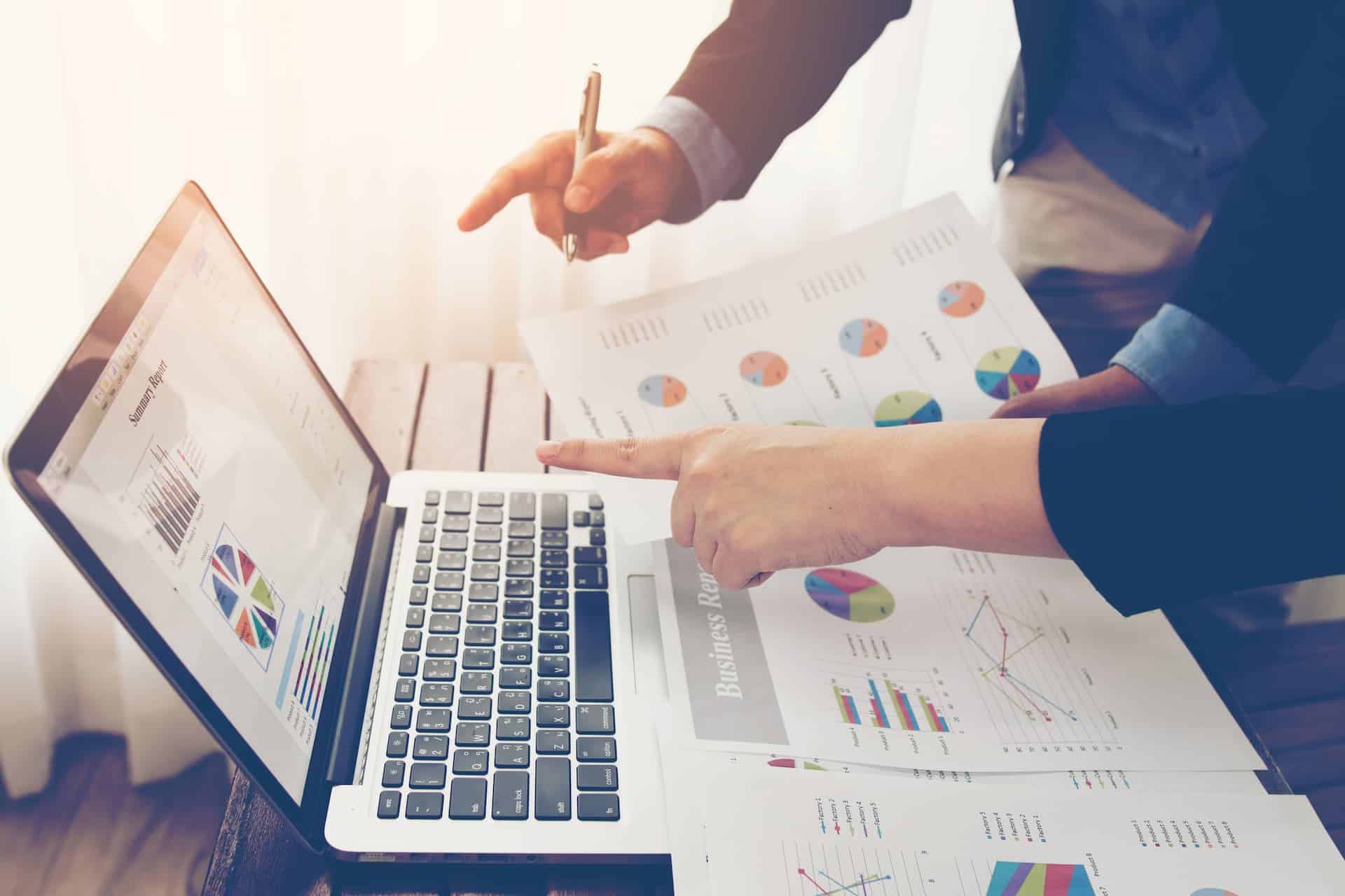 Hands over a laptop showing how a team analyzes industry trends.