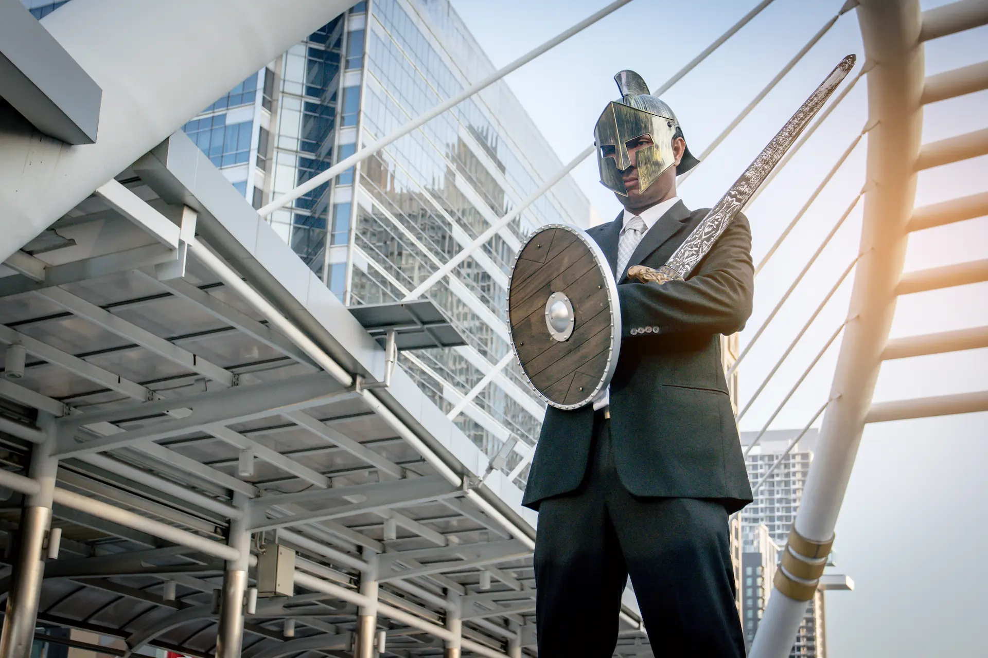 A businessman wearing a knight’s suit and shield, representing the protective armor people use in professional settings.