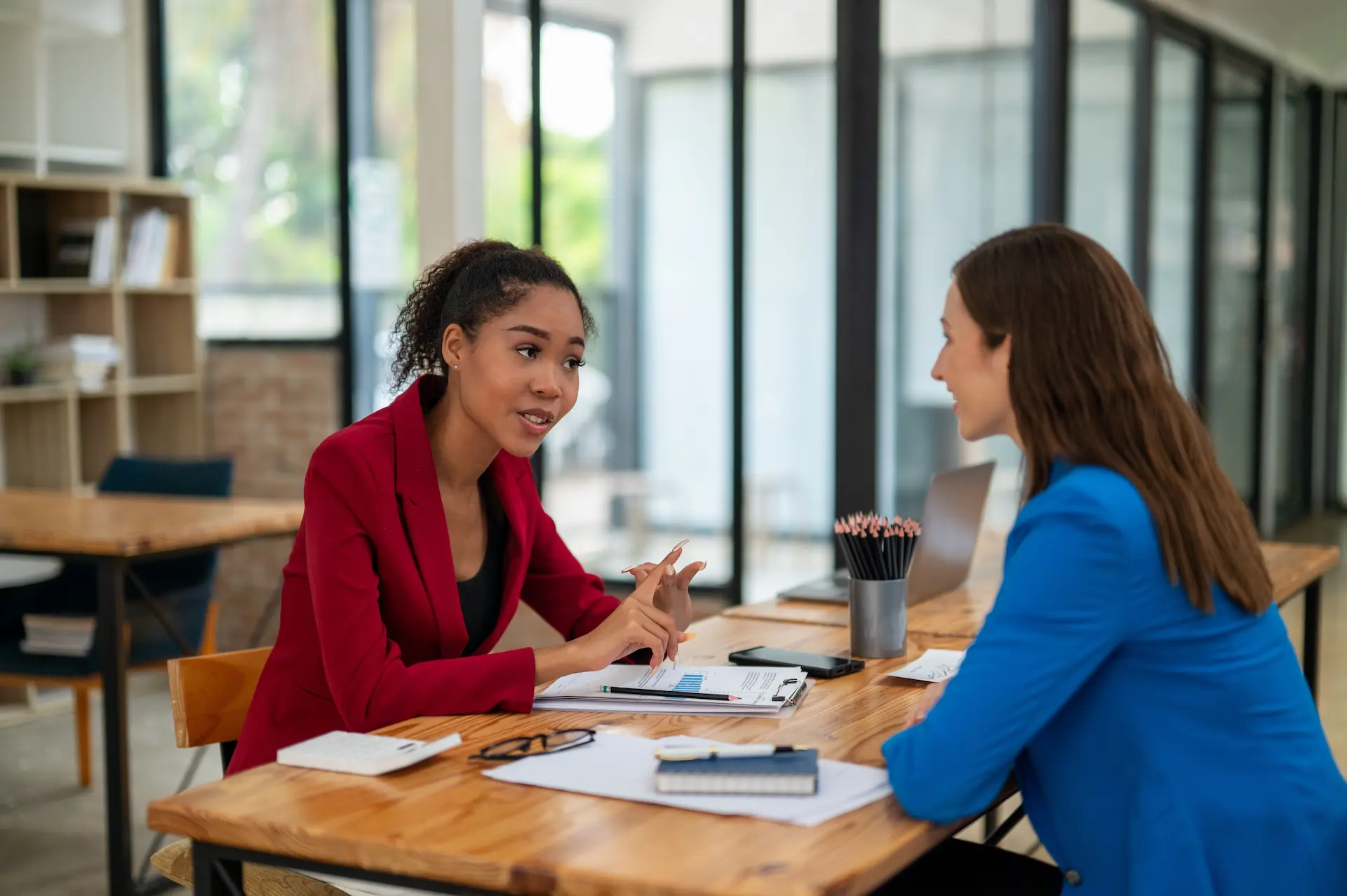 Two women in a meeting where one is offering support to the other, showcasing the role of connections and networking.