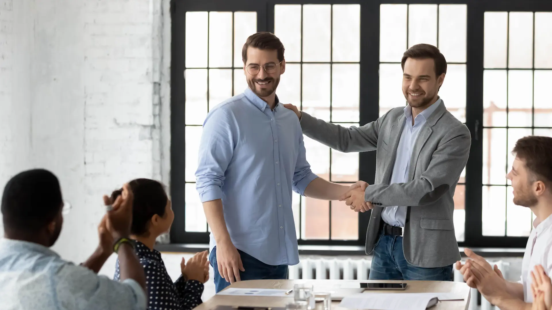 A boss praises a team member in front of colleagues, showcasing the power of recognition and reward.
