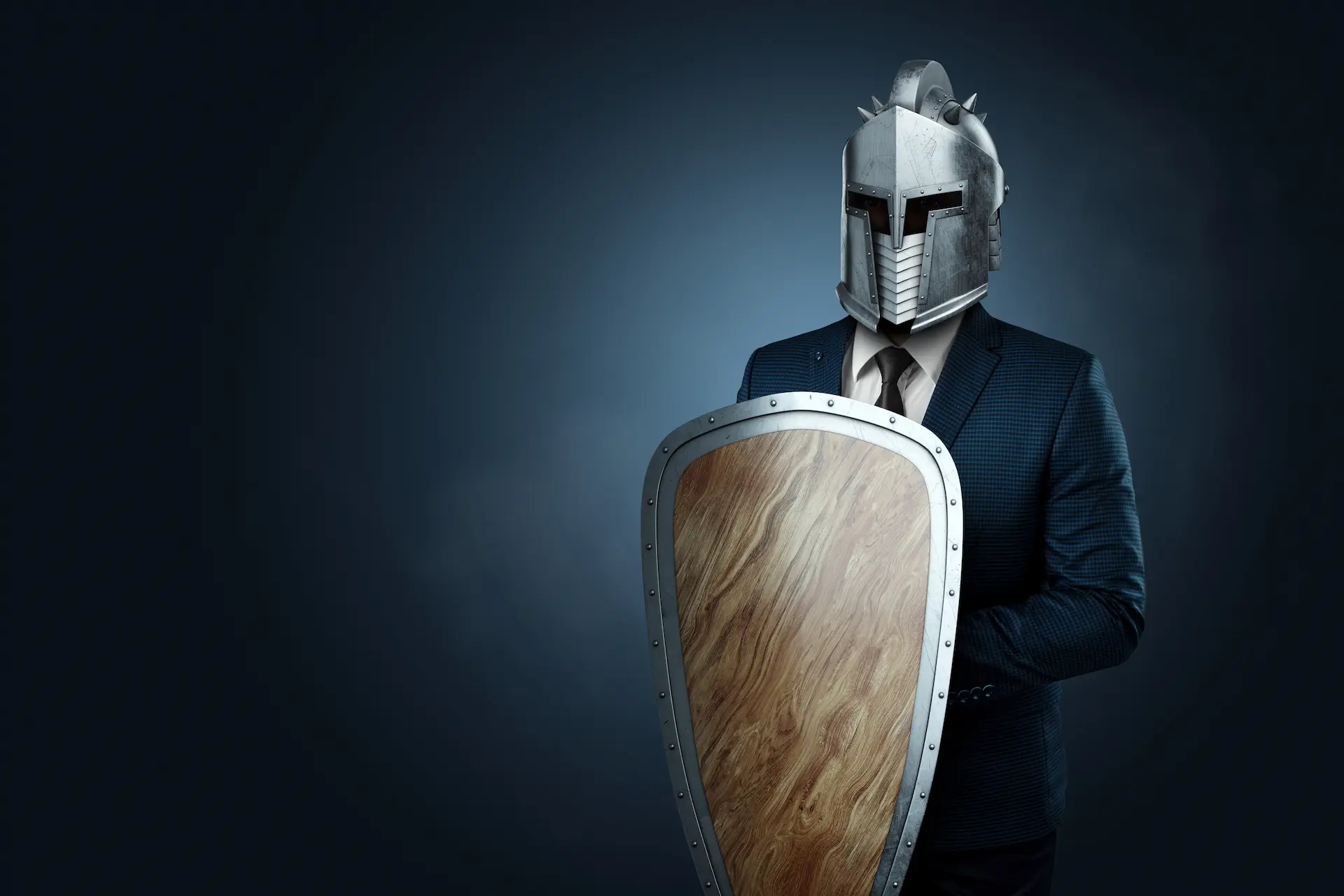 A businessman wearing a shield as a metaphor for the behaviors we use to protect ourselves from others.