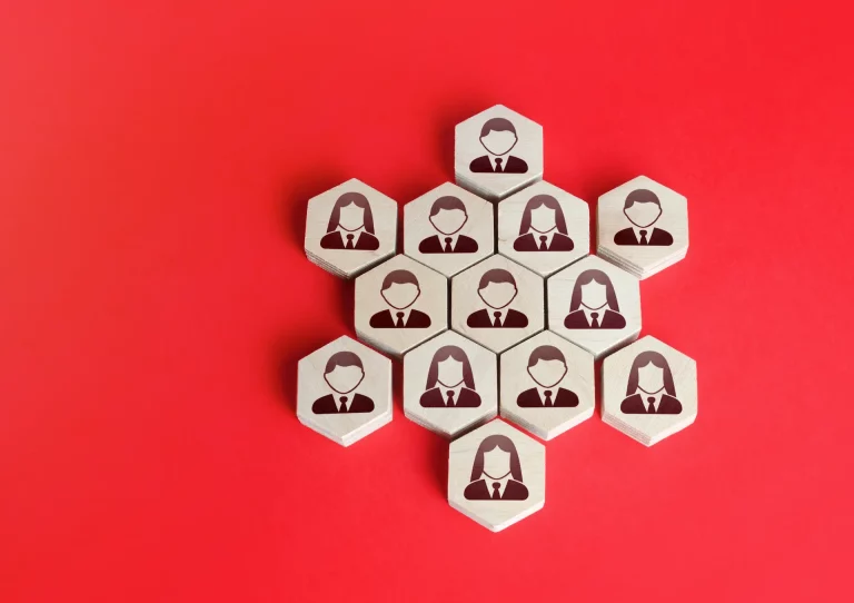 Hexagonal tiles with business icons of men and women arranged in a honeycomb pattern, symbolizing how a non-hierarchical organization is based on a network of collaborators.