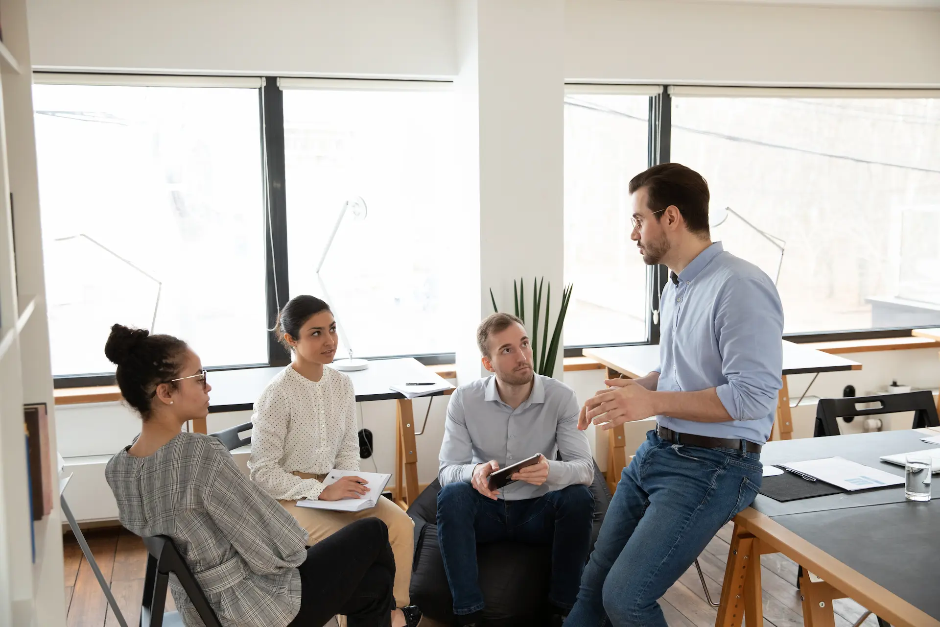 A group of people having a meeting in a non-hierarchical organization where ideas flow naturally, given the freedom to express opinions regardless of job title.