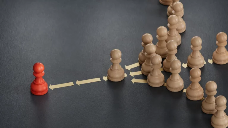 A symbolic image of followership, with a bold red chess piece leading a line of plain wooden ones, representing influence and leadership dynamics.
