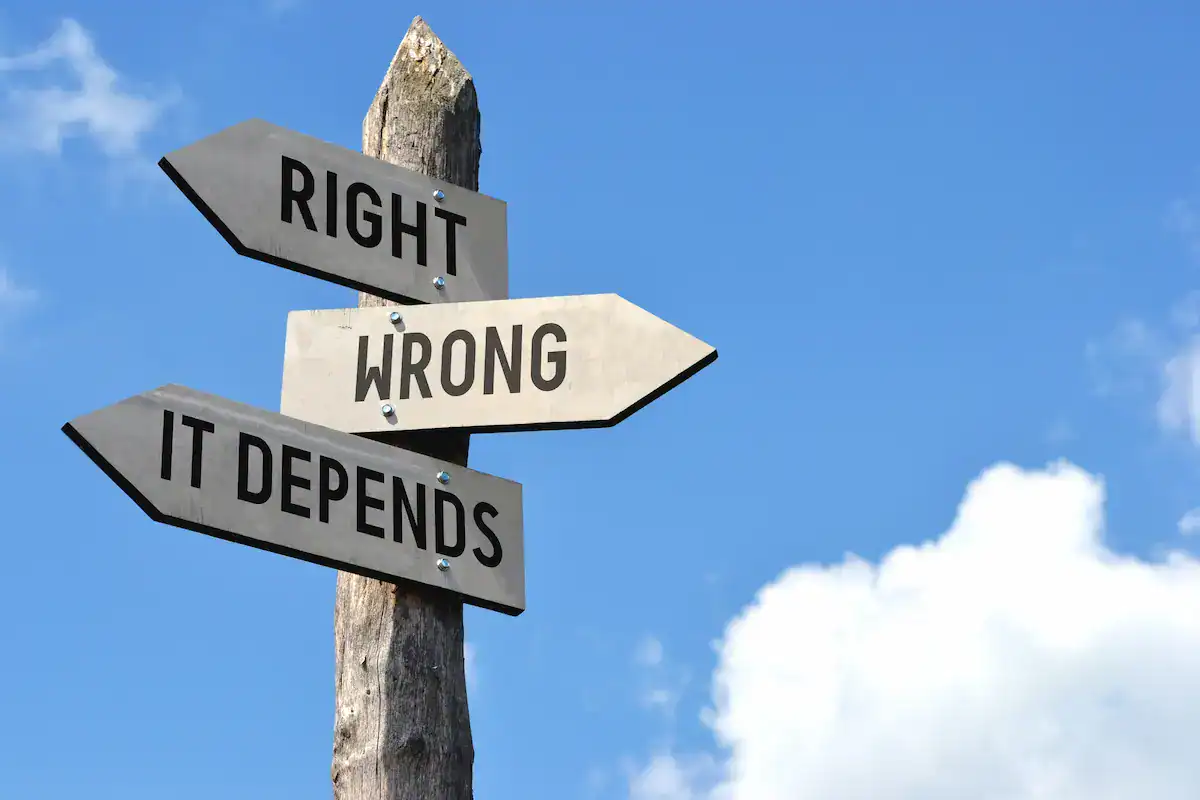 A wooden signpost against a blue sky with three directional arrows labeled 'RIGHT', 'WRONG,' and 'IT DEPENDS', highlighting ethical decision-making ambiguity.