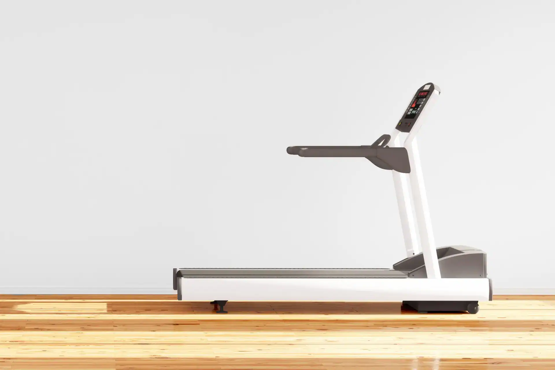 A modern treadmill in a minimalist room with light wooden flooring and a plain white wall.