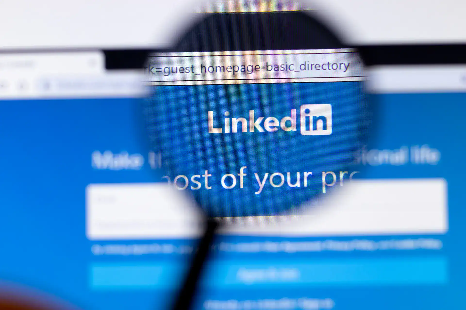 A laptop screen displays LinkedIn’s landing page and URL in a browser window.