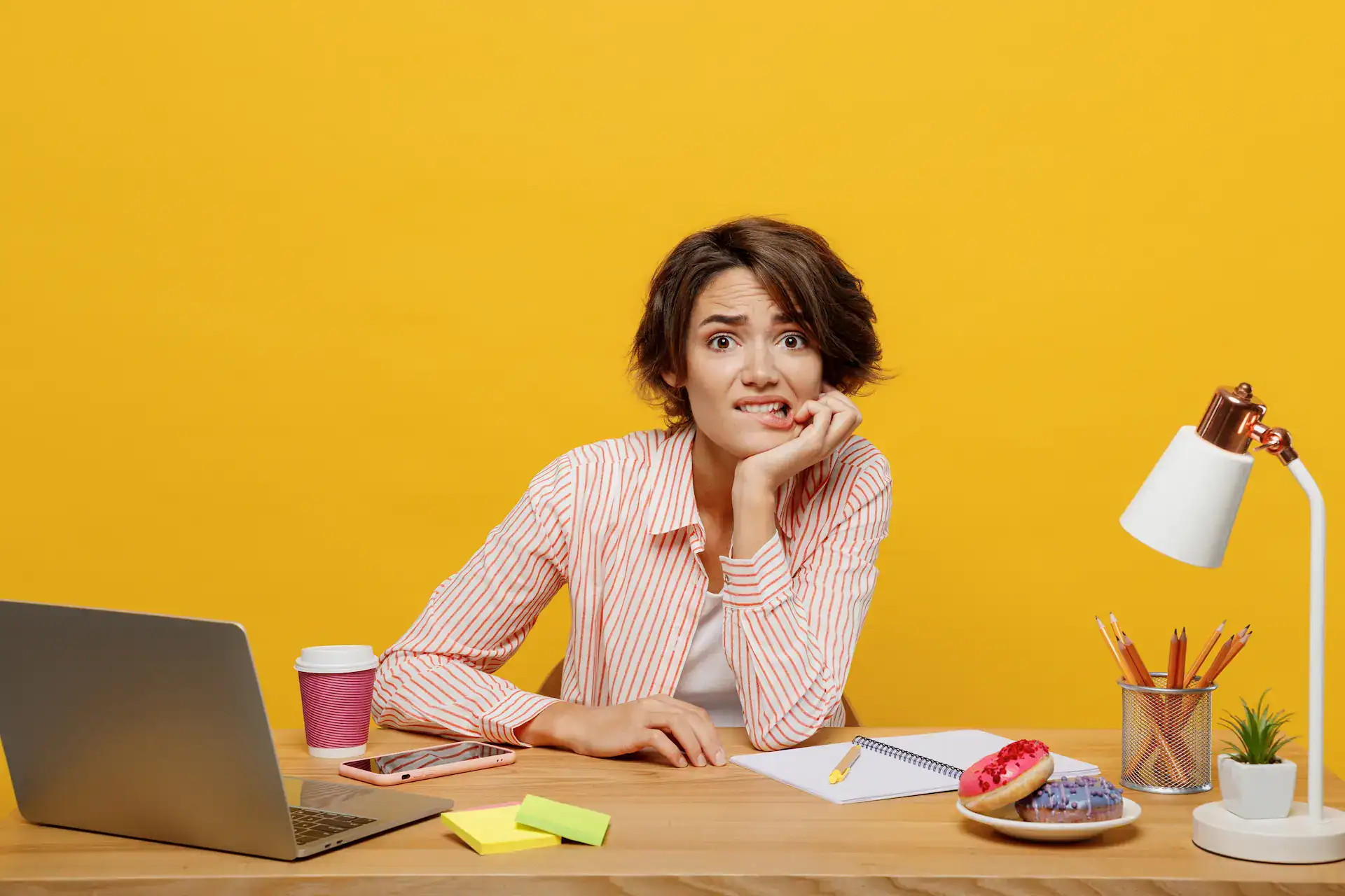 A woman looks nervous while working on her laptop, reflecting career concerns about AI's impact.