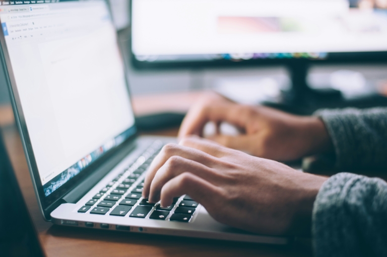 A man typing up an email sign off