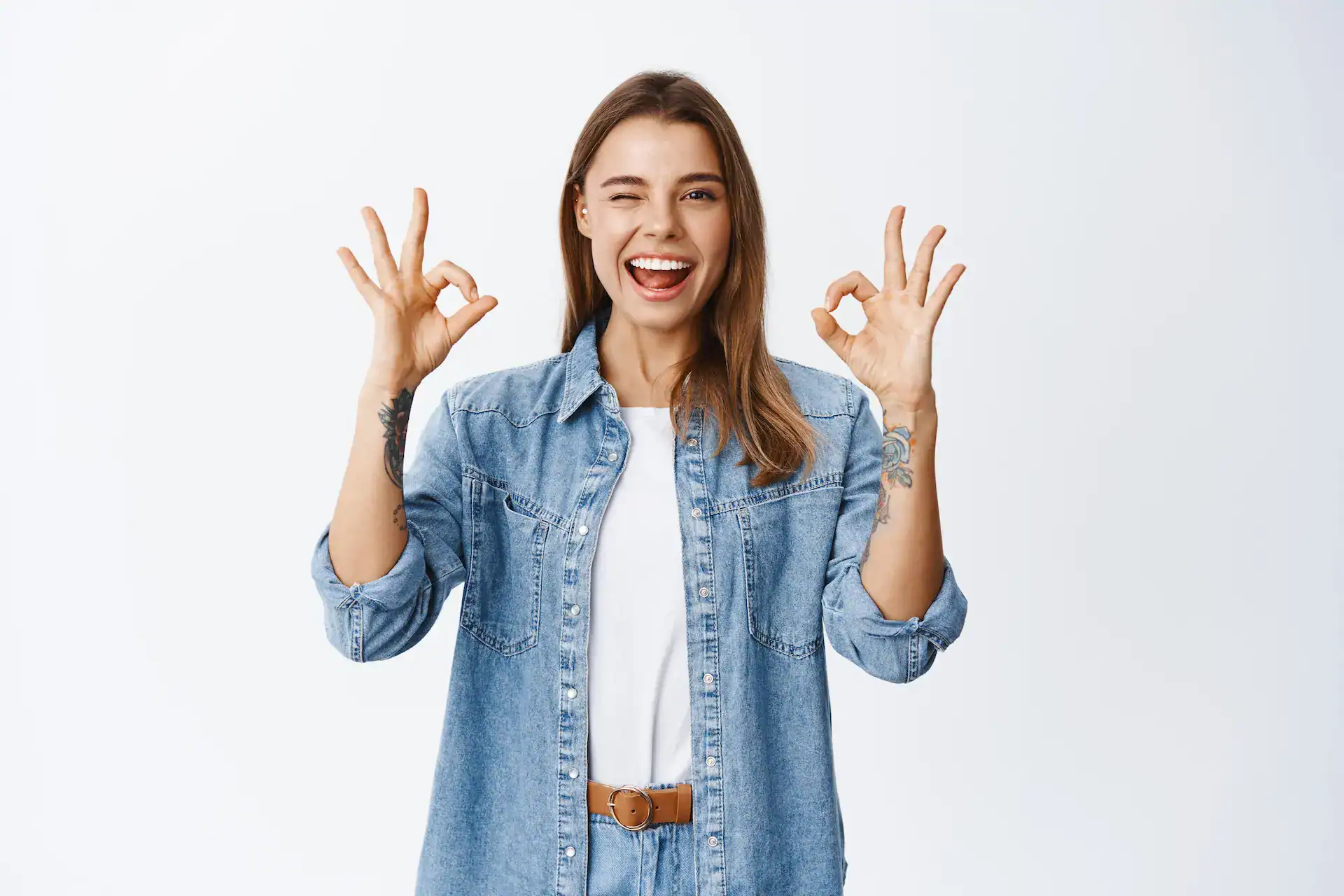 A smiling woman winks and makes "okay" gestures with both hands, representing positive affirmation and recognition.