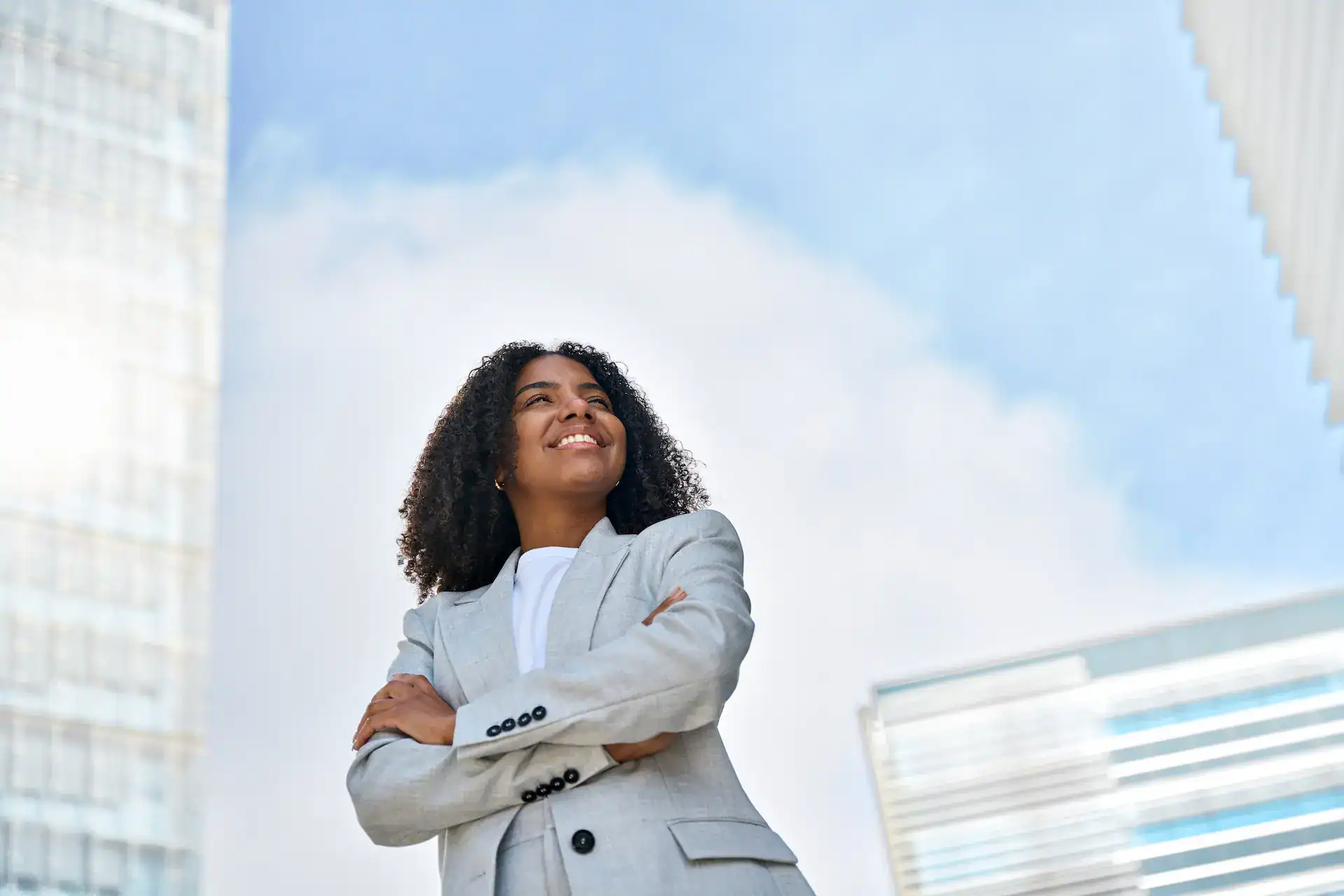 A woman in a suit with her arms crossed, showing the confidence that Quiet Leadership brings to team members.