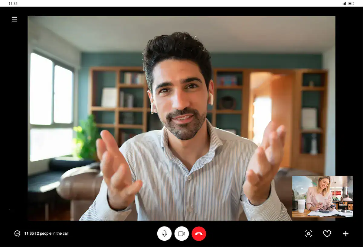 A man smiles and gestures toward his webcam while a smaller inset window shows a woman, depicting the personal development aspect of remote presence.