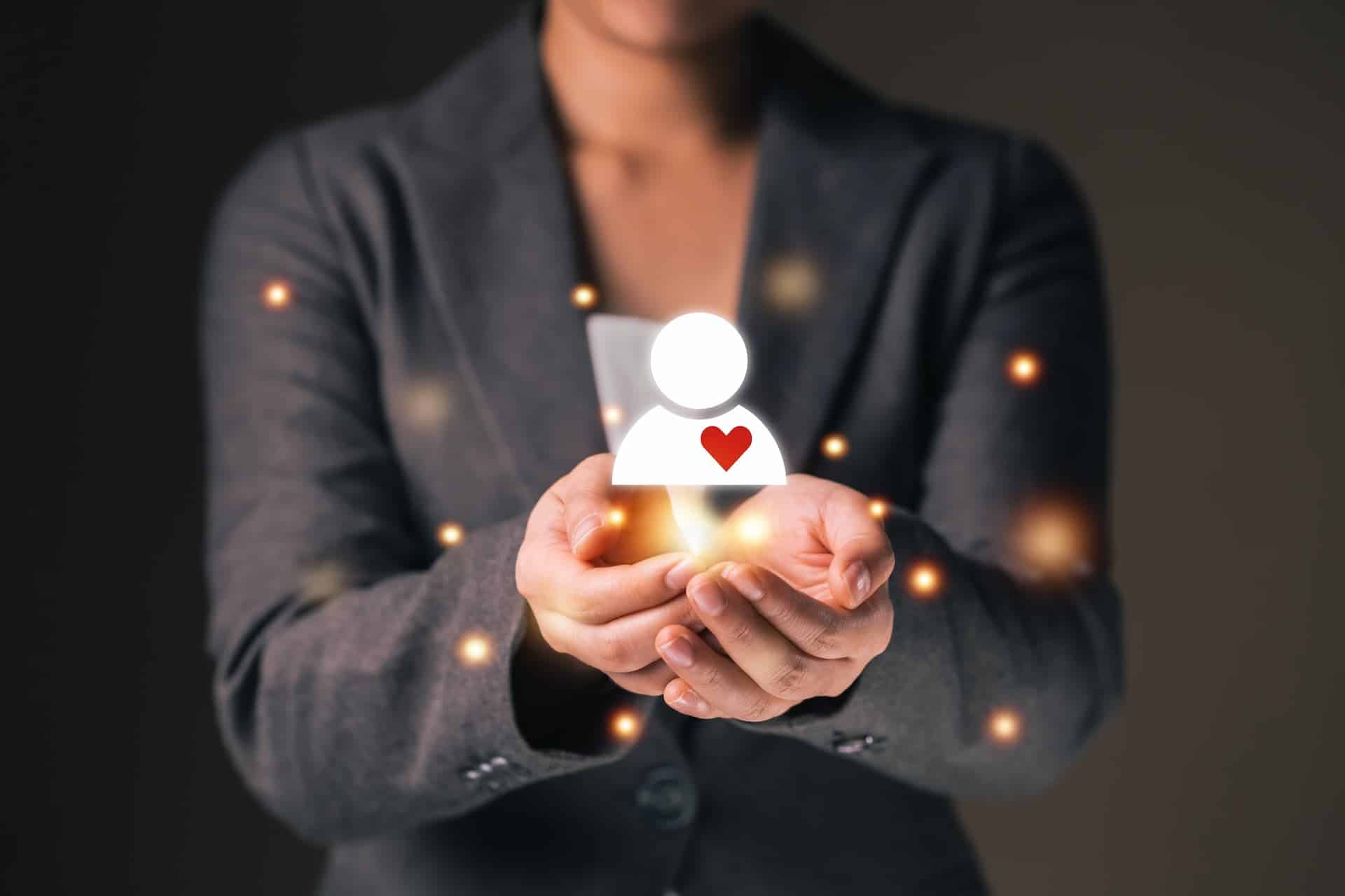 A woman holding a human icon with a heart, symbolizing empathy and understanding under pressure