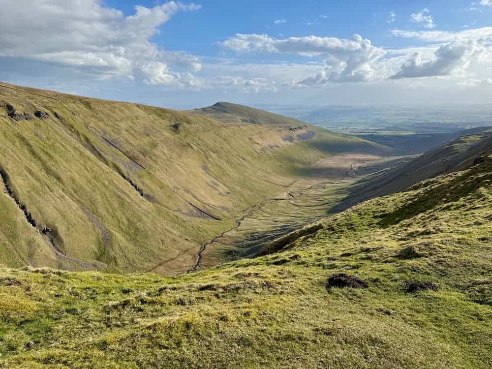 Expansive green valley along the Pennine Way in the UK, representing a long journey, reflection, and steady progress over time.