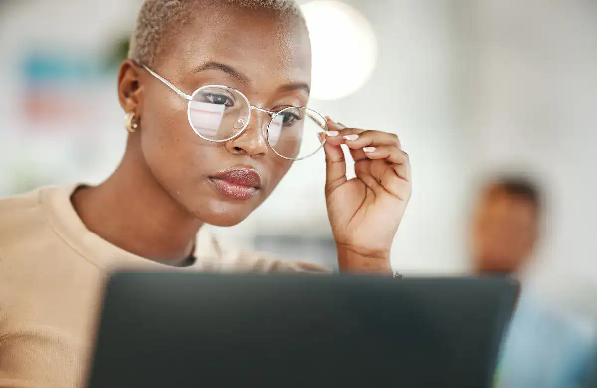 Professional reading career development articles on a laptop.